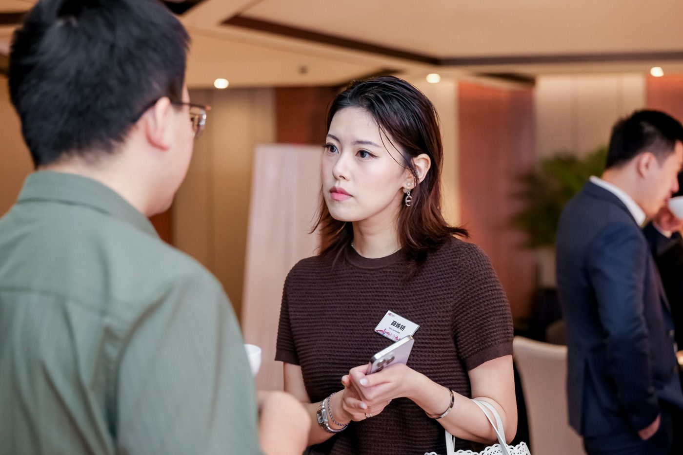 薛姝钥在会议间隙与一位创始人交谈